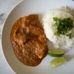 a plate of butter chicken and rice