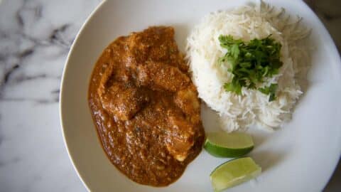 a plate of butter chicken and rice