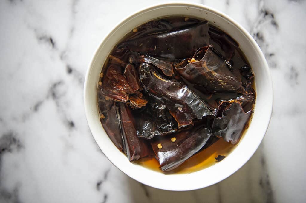 dried peppers soaking in water in a bowl