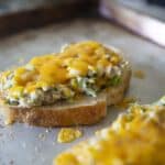 An open Tuna melt sandwich on a baking sheet
