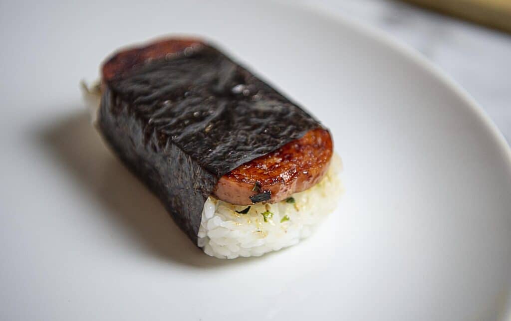 One Spam musubi on a white plate