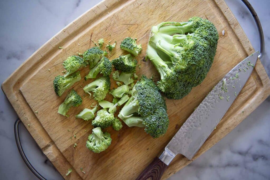Cut up broccoli on a cutting board