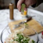 Freshly squeezed lime over a bowl of coleslaw.