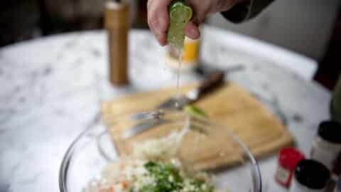 Freshly squeezed lime over a bowl of coleslaw.