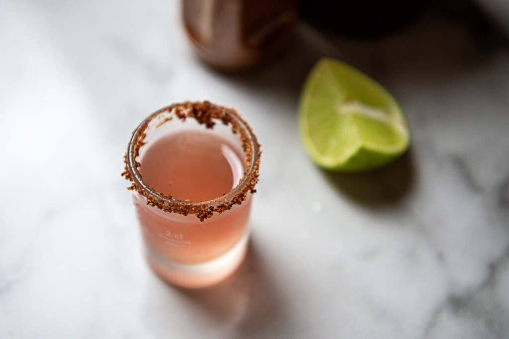 a Mexican candy shot next to a lime wedge