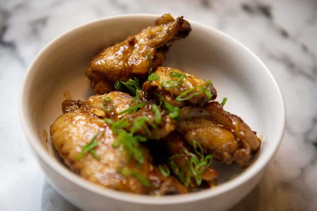 A bowl of glossy chicken wings.