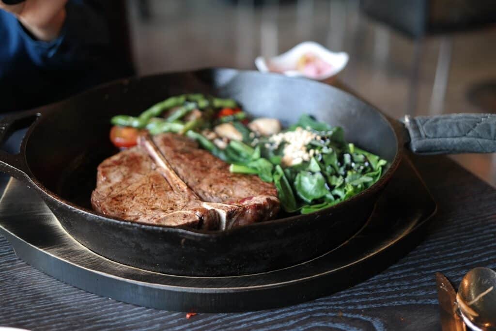 Steak Resting In A Cast Iron Skillet with Spinach and Garlic