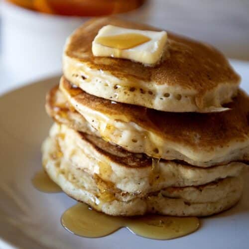 A stack of pancakes with butter and maple syrup