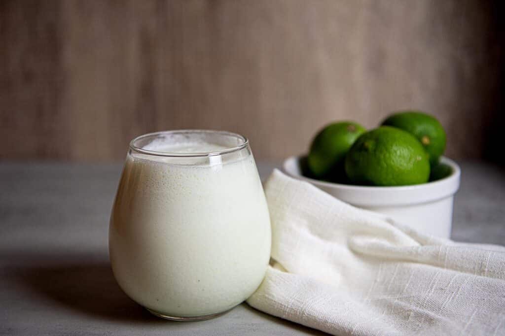 a glass of limonada and limes