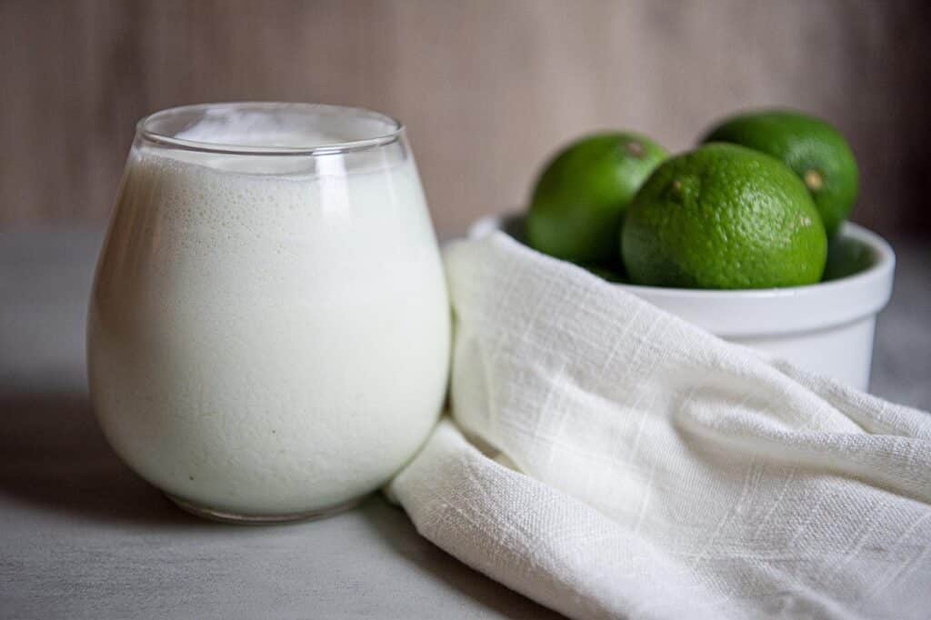 a glass of limonada with limes