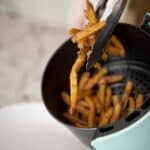 Pulling a bunch of Checkers fries out of an air fryer.