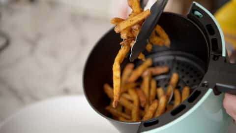 Pulling a bunch of Checkers fries out of an air fryer.