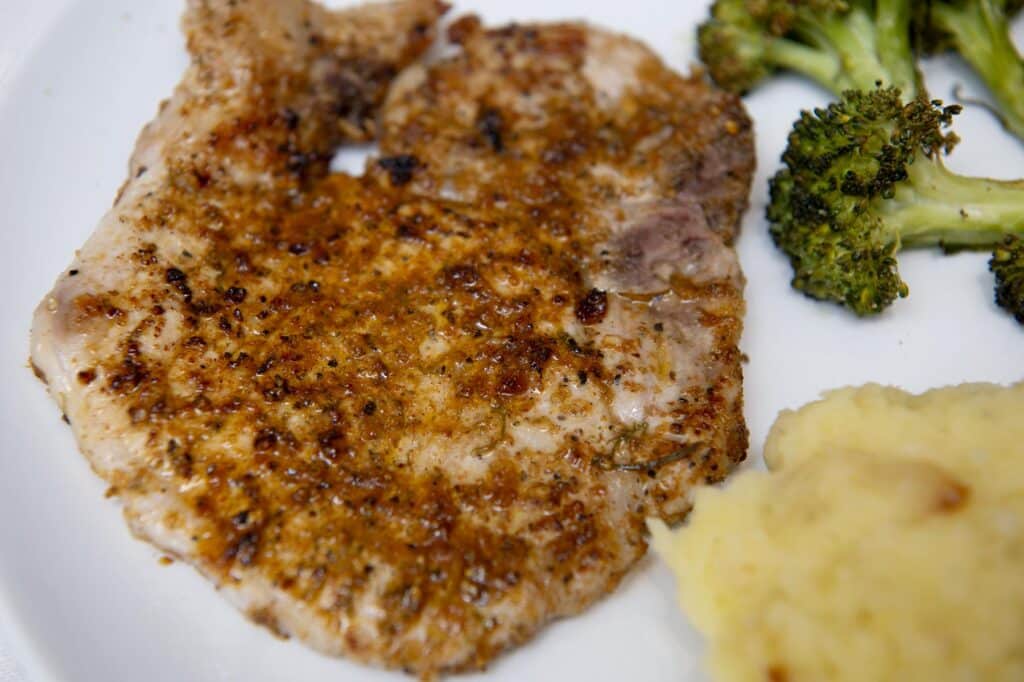 lemon pepper pork chops with mashed potatoes and broccoli