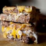A close up shot of a crab melt sandwich on a cutting board.