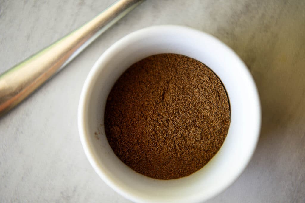 The spice blend known as Allspice sitting in a container.