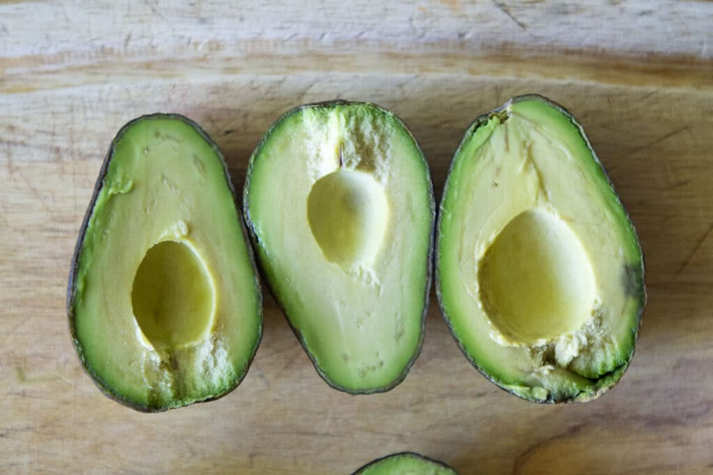 Avocados sitting out on a cutting board.