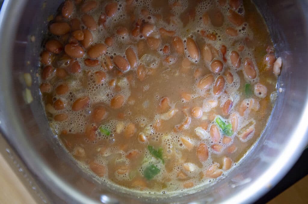 A shot of pinto beans being cooked down for Sonoran dogs.