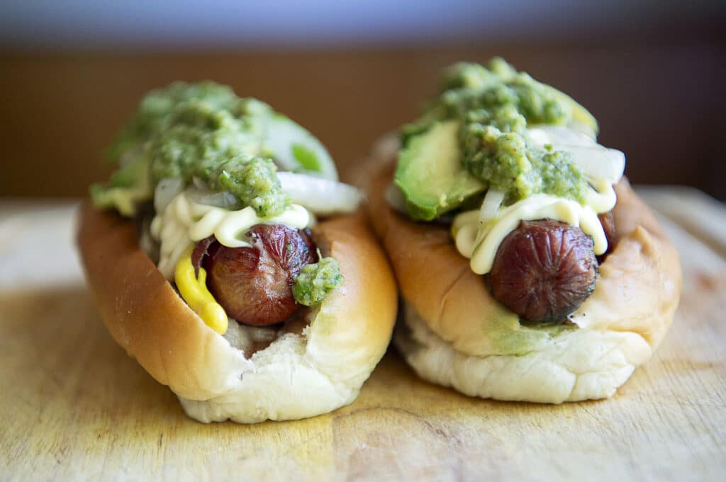 Sonoran dogs sitting on a cutting board, waiting to be eaten.