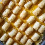 A close-up view of a Tater Tot Hotdish shows rows of golden-brown tater tots over melted cheddar cheese in a clear baking dish.