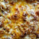 Close-up of baked lasagna with melted, golden-brown cheese on top. The surface shows bubbly, crispy, and slightly browned spots, capturing the delicious texture similar to a classic Baked Spaghetti Recipe.