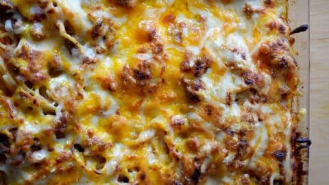 Close-up of baked lasagna with melted, golden-brown cheese on top. The surface shows bubbly, crispy, and slightly browned spots, capturing the delicious texture similar to a classic Baked Spaghetti Recipe.