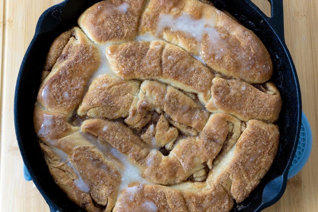 Dollywood cinnamon bread with glaze in a cast iron pan.