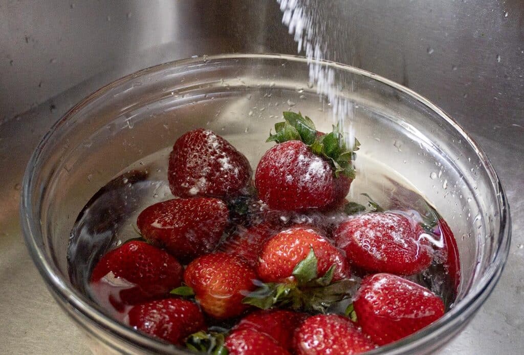 Strawberries being washed in baking soda