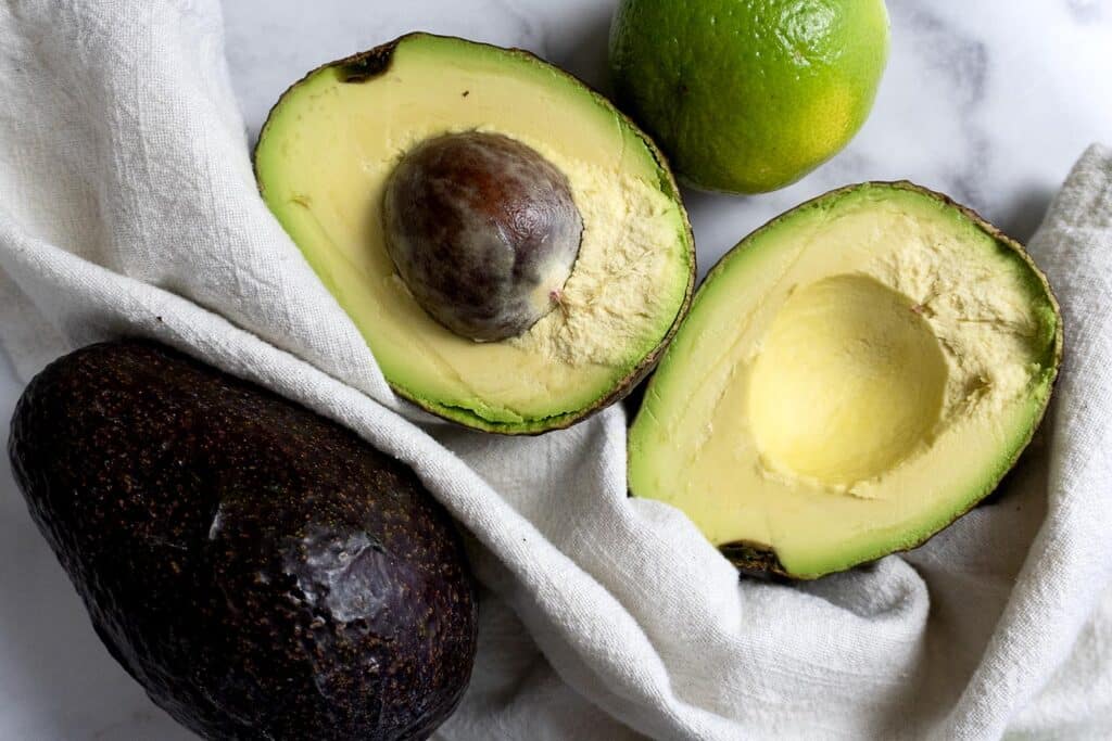A avocado cut in half and a lime.
