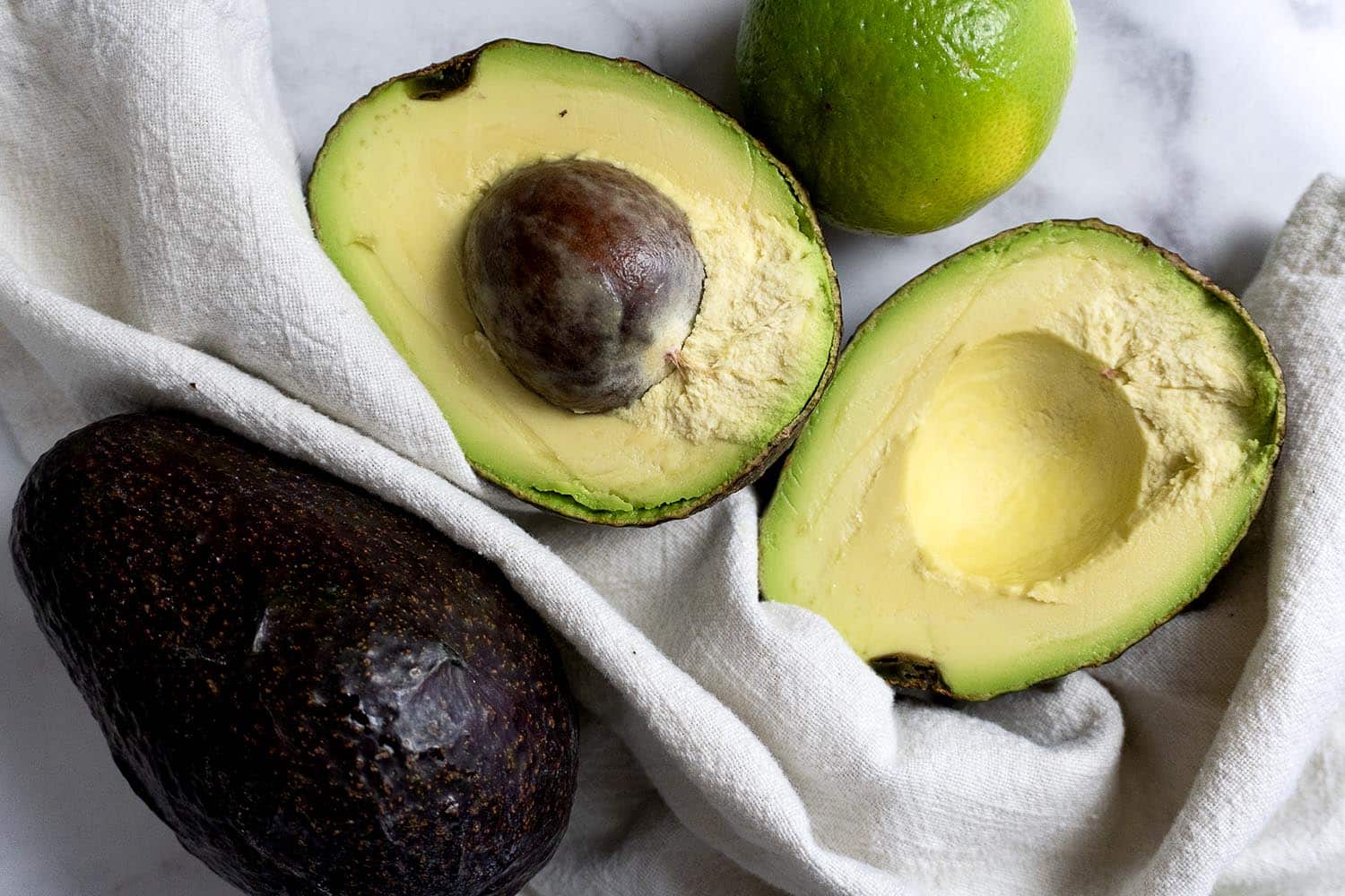A avocado cut in half and a lime.